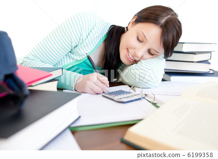 Attractive student doing her homework on a desk Attractive student doing her homework on a desk 6199358