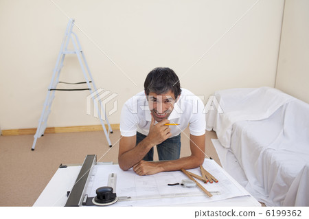 Smiling architect man refurbishing a bedroom Smiling architect man refurbishing a bedroom 6199362