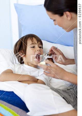Mother giving her son syrup Mother giving her son syrup 6199437