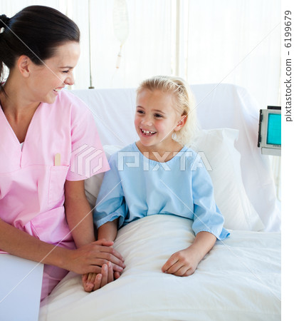 Smiling little girl sitting on a hospital bed with her doctor Smiling little girl sitting on a hospital bed with her doctor 6199679