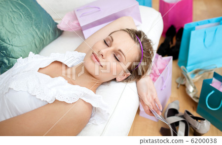 Happy woman relaxing after shopping surrounded with shopping bag Happy woman relaxing after shopping surrounded with shopping bag 6200038