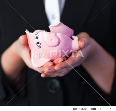 Business woman holding a broken piggy bank Business woman holding a broken piggy bank 6200058