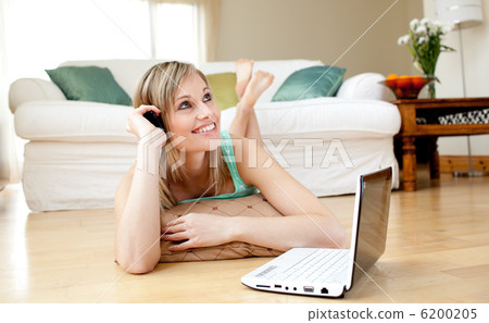 Happy woman using a laptp lying on the floor Happy woman using a laptp lying on the floor 6200205