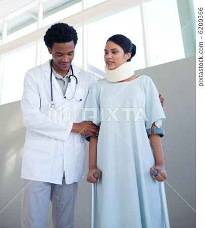 Physical therapist helping a woman on crutches 6200366