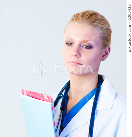 Serious doctor holding a clipboard Serious doctor holding a clipboard 6200438