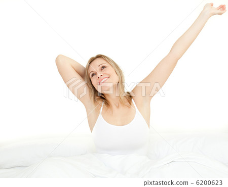 Delighted woman stretching sitting on her bed Delighted woman stretching sitting on her bed 6200623