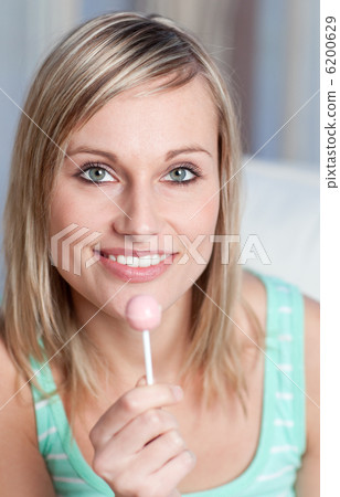 Radiant woman holding a lollipop 6200629
