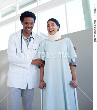 Smiling doctor helping a female patient on crutches 6200716