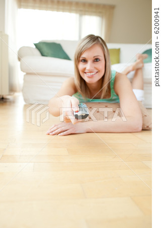 Pretty young woman watching TV lying on the floor Pretty young woman watching TV lying on the floor 6200941