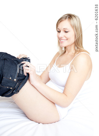 Smiling woman wearing a jeans on a bed Smiling woman wearing a jeans on a bed 6201638