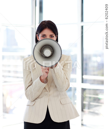 Businesswoman shouting through megaphone to the camera 6202409