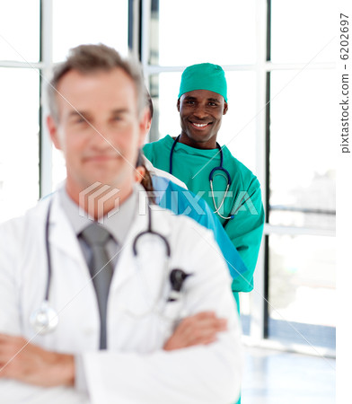 Smiling surgeon with folded arms in a line Smiling surgeon with folded arms in a line 6202697
