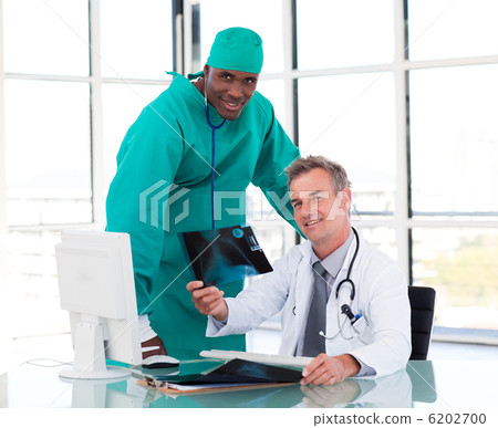Senior doctor and young surgeon studying an X-ray Senior doctor and young surgeon studying an X-ray 6202700