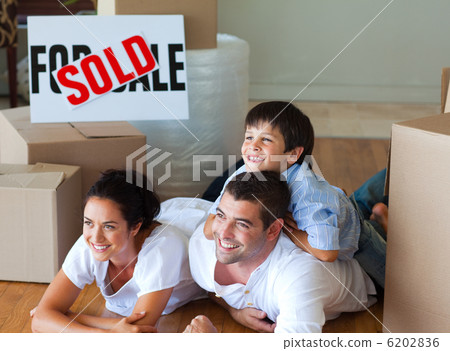 Family buying new house lying on floor 6202836