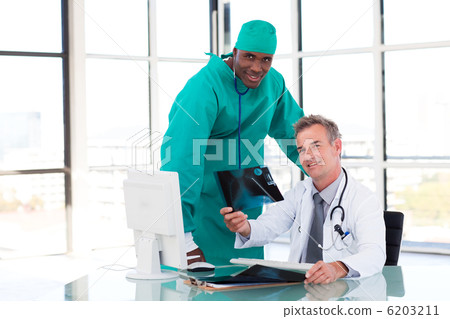 Doctor and surgeon looking at an X-ray Doctor and surgeon looking at an X-ray 6203211