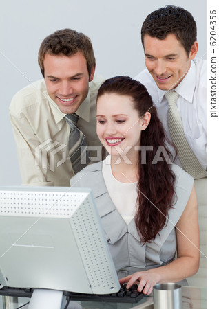 Businessmen helping a businesswoman with a computer Businessmen helping a businesswoman with a computer 6204356