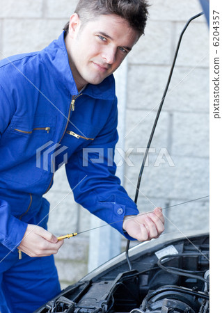 Confident man repairing a car Confident man repairing a car 6204357