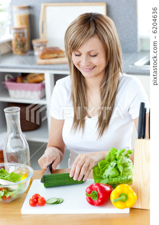 Delighted woman preparing a healthy meal in the kitchen Delighted woman preparing a healthy meal in the kitchen 6204636