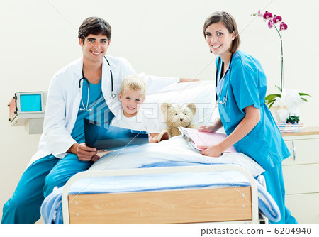 A doctor and a nurse showing an x-ray to a little boy 6204940