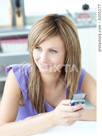 Delighted woman using a phone in the kitchen 6205277