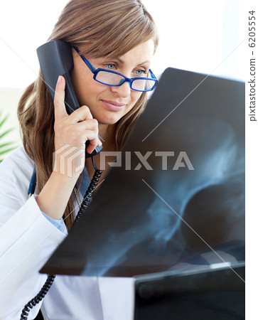 Concentrated female doctor talking on the phone 6205554