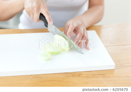 Delighted woman preparing onion in the kitchen Delighted woman preparing onion in the kitchen 6205670