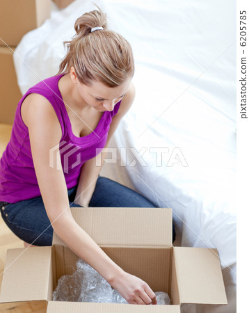 Radiant woman unpacking box Radiant woman unpacking box 6205785