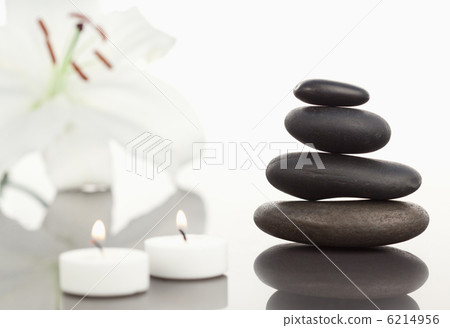 White orchid with lighted white candles and a black pebbles stac White orchid with lighted white candles and a black pebbles stac 6214956