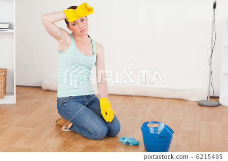 Cute red-haired woman having a break while cleaning the floor 6215495