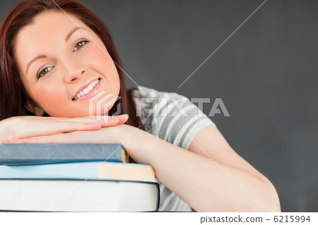 Smiling young student leaned on her books 6215994