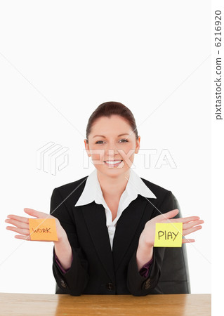 Portrait of a smiling businesswoman torn between work and play 6216920