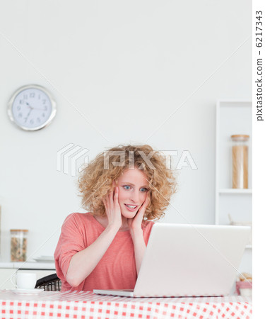Pretty blonde female relaxing with her laptop while sitting in t Pretty blonde female relaxing with her laptop while sitting in t 6217343