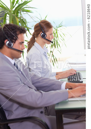 Call center agents working next to each other Call center agents working next to each other 6218640