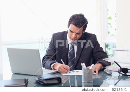 Businessman working on statistics Businessman working on statistics 6218641