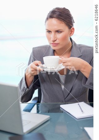 Portrait of a serious businesswoman drinking tea 6218646