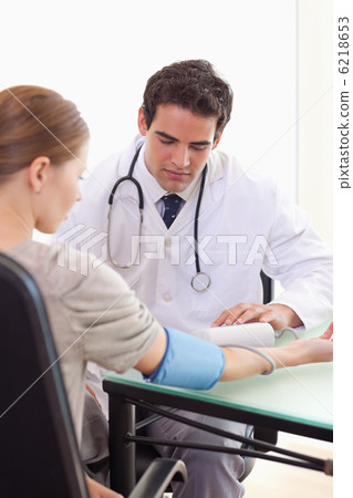 Doctor taking his patients blood pressure Doctor taking his patients blood pressure 6218653