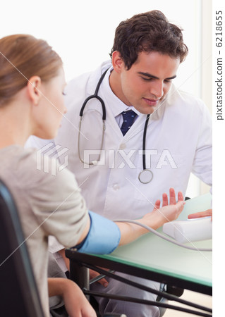 Doctor measuring his patients blood pressure Doctor measuring his patients blood pressure 6218655