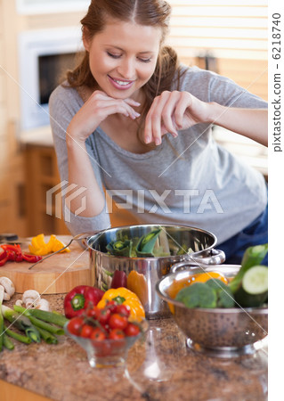 Woman flavouring the ingredients of her meal 6218740