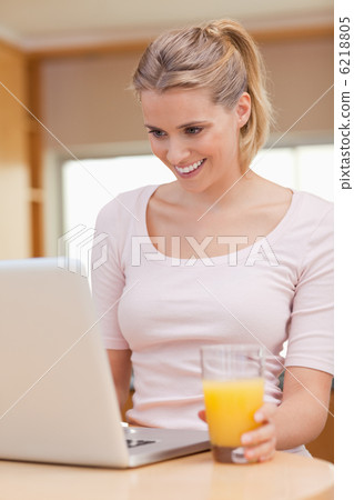 Portrait of a woman using a notebook while drinking juice 6218805