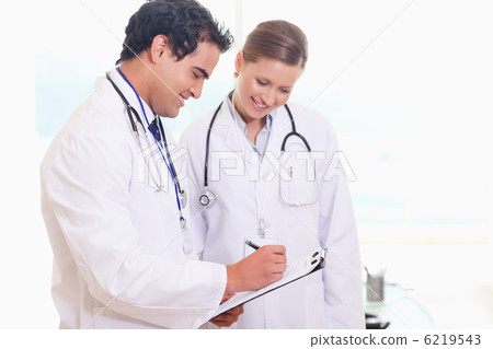 Young medical staff working on patient record Young medical staff working on patient record 6219543