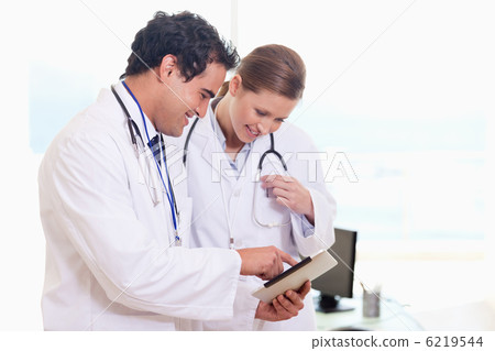 Medical assistants looking at clip board Medical assistants looking at clip board 6219544