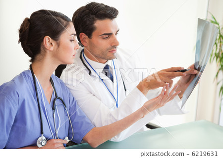 Serious doctors looking at a set of X-ray Serious doctors looking at a set of X-ray 6219631