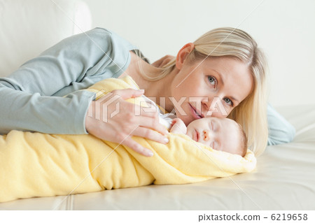 Mom relaxing next to her baby Mom relaxing next to her baby 6219658