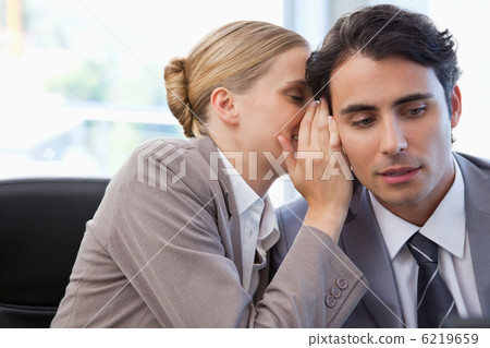 Businesswoman whispering something to her colleague Businesswoman whispering something to her colleague 6219659