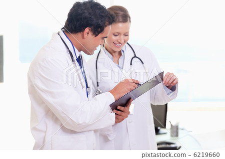 Assistant doctors reading off clip board 6219660