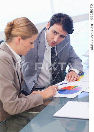 Portrait of young business people studying statistics Portrait of young business people studying statistics 6219670
