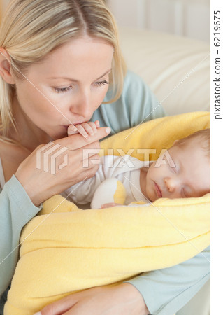Close up of mother kissing her baby's hand Close up of mother kissing her baby's hand 6219675