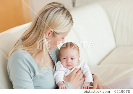 Mother on the sofa with her newborn on her lap 6219678