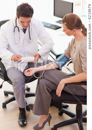 Side view of doctor taking his patients blood pressure Side view of doctor taking his patients blood pressure 6219679
