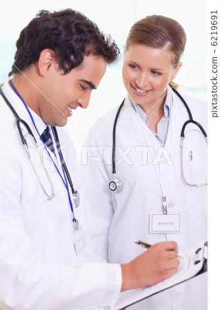 Doctors analyzing patient record Doctors analyzing patient record 6219691